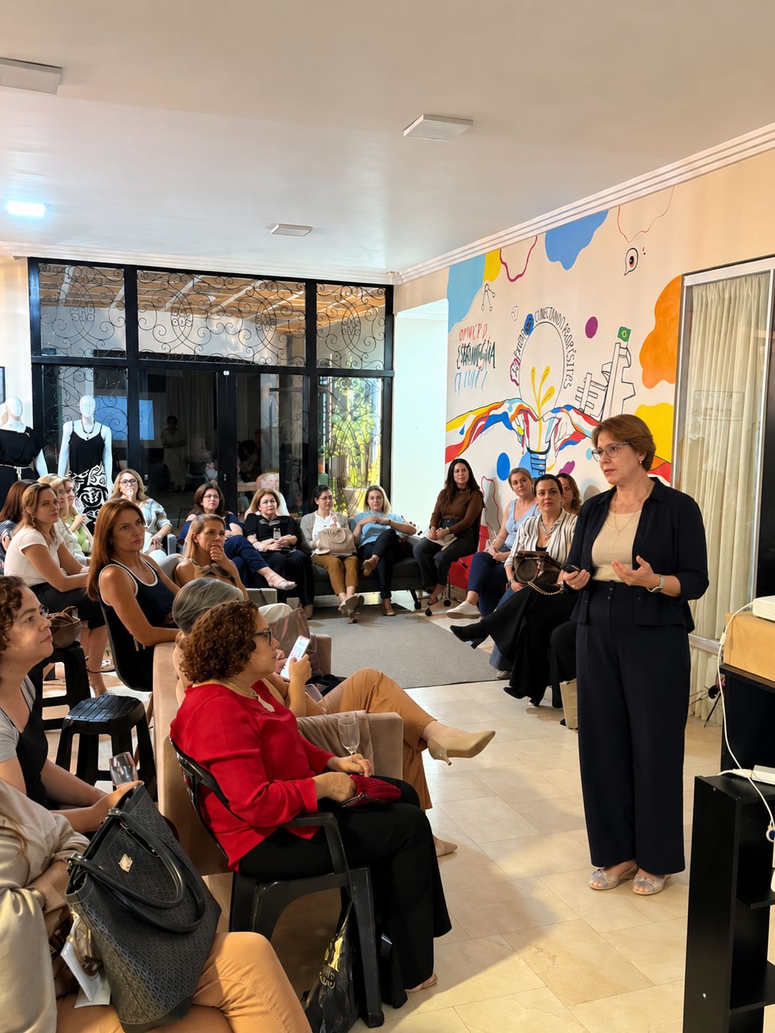 Ana Cláudia Mira apresentando para um grupo de mulheres